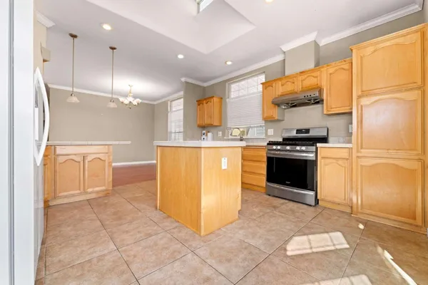 a kitchen with stainless steel appliances granite countertop a stove a refrigerator a sink a oven with white cabinets and wooden floor