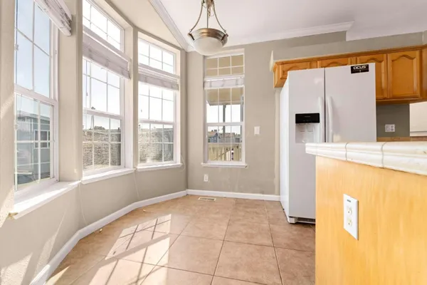 a view of empty room with a window and kitchen view