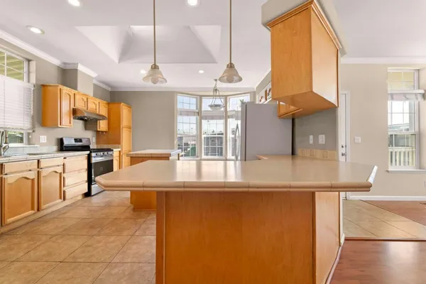 a large kitchen with kitchen island granite countertop a large window