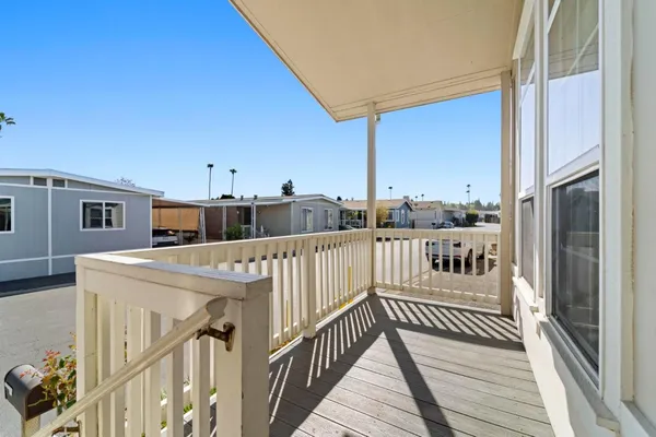 a view of a balcony with wooden floor and fence