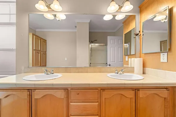 a bathroom with a sink a large mirror and a light fixture a lamp