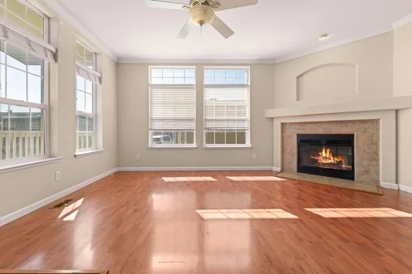 wooden floor fireplace and windows in an empty room