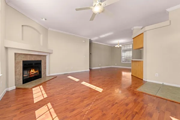 a view of empty room with wooden floor and fireplace