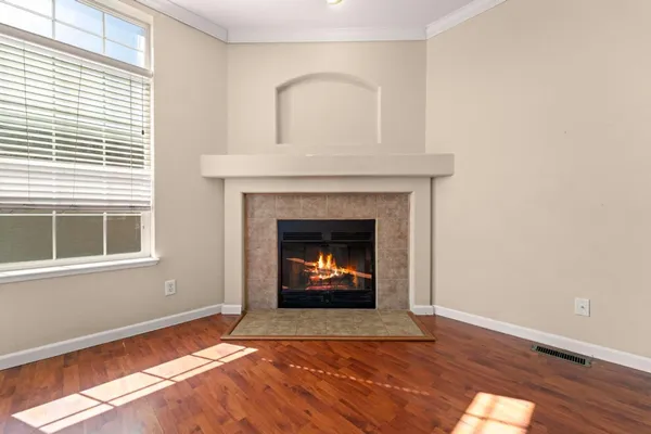 a view of an empty room with a fireplace and window