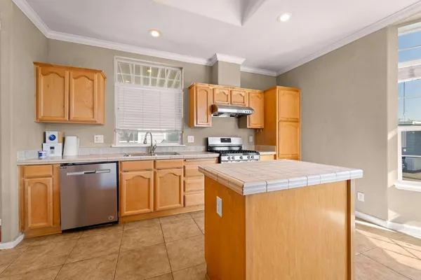 a kitchen with stainless steel appliances granite countertop a sink stove and refrigerator