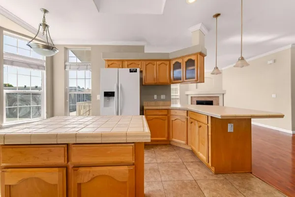a kitchen with stainless steel appliances kitchen island granite countertop a refrigerator and a stove top oven