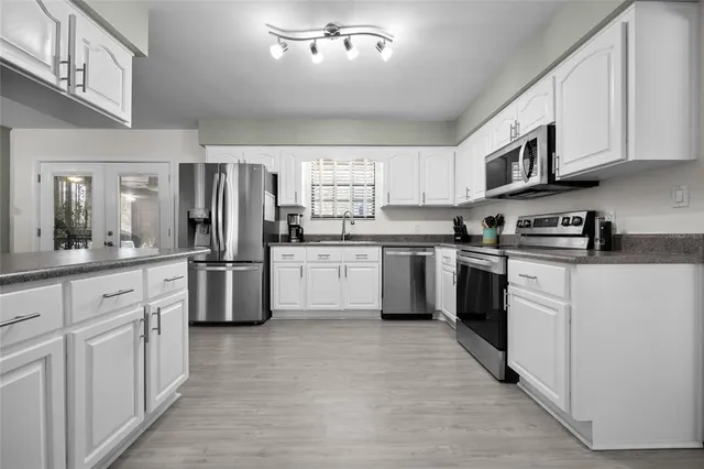 a kitchen with white cabinets stainless steel appliances and sink