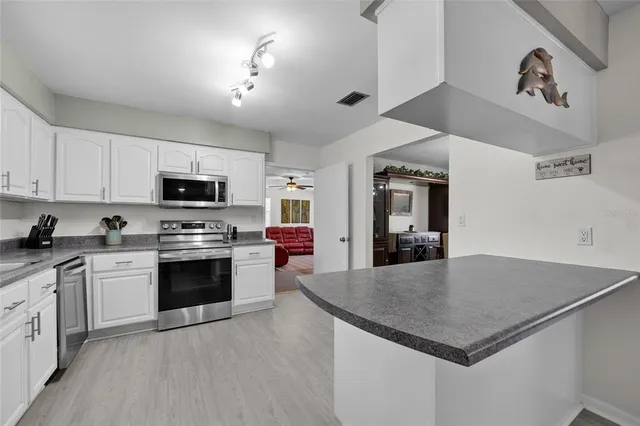 a kitchen with sink a microwave and cabinets