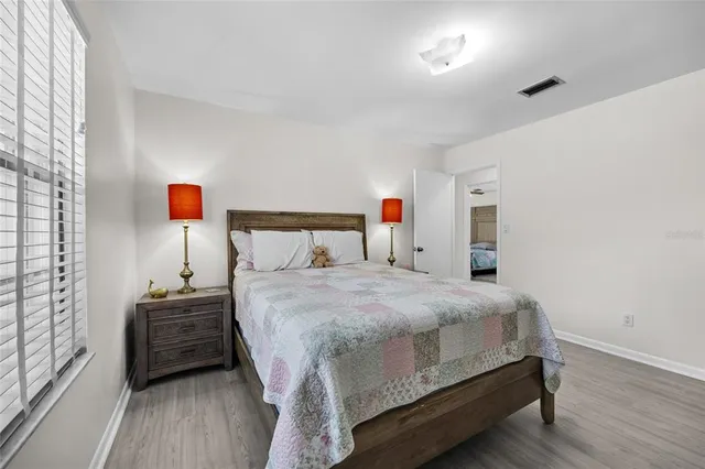 a bedroom with a bed and wooden floor