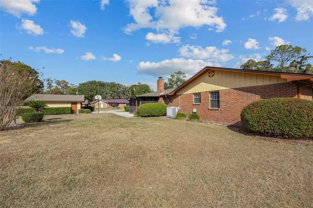 a view of a house with a yard and sitting area