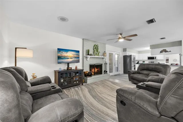 a living room with furniture a fireplace and a flat screen tv