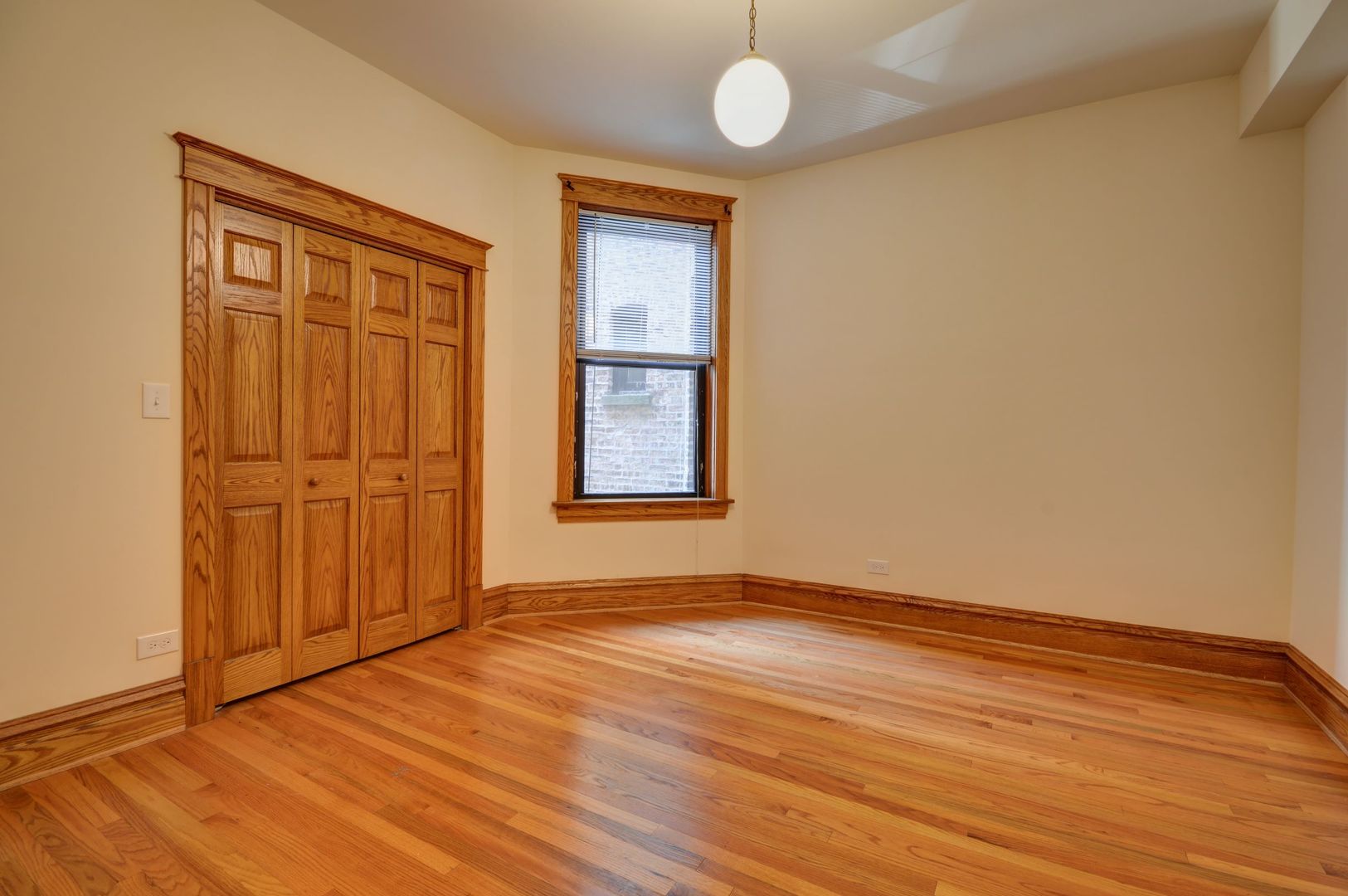 3724 North Fremont Street, Unit 2 Chicago, IL 60613 - Photo 11 of 14 an empty room with wooden floor and cabinet