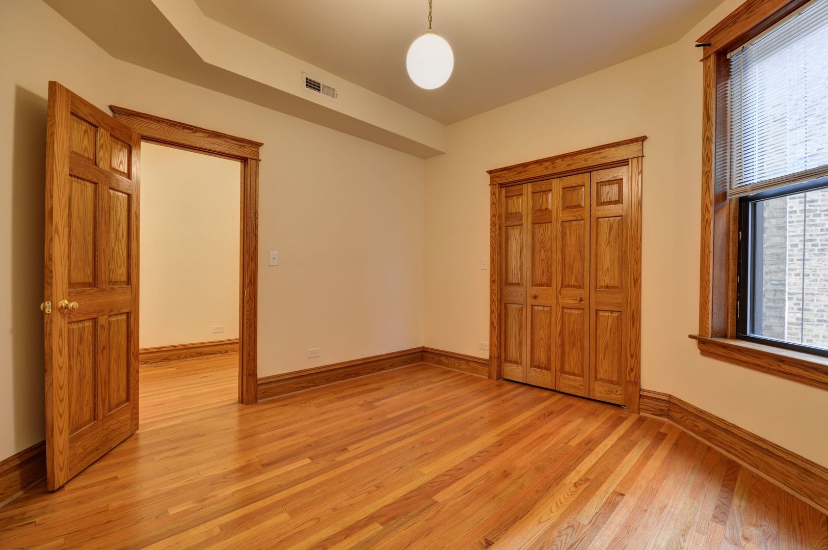 3724 North Fremont Street, Unit 2 Chicago, IL 60613 - Photo 12 of 14 an empty room with wooden floor and windows
