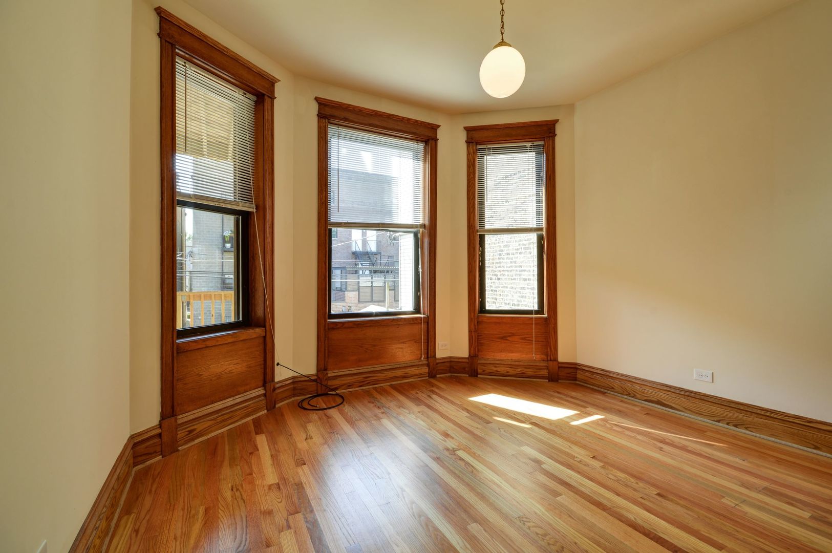 3724 North Fremont Street, Unit 2 Chicago, IL 60613 - Photo 2 of 14 an empty room with wooden floor and windows