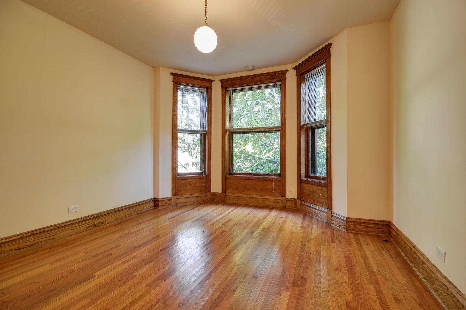 3724 North Fremont Street, Unit 2 Chicago, IL 60613 - Photo 3 of 14 a view of an empty room with wooden floor and a window