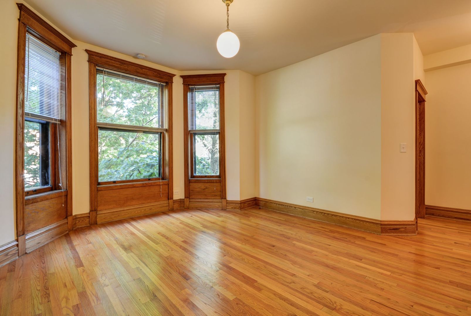 3724 North Fremont Street, Unit 2 Chicago, IL 60613 - Photo 4 of 14 a view of an empty room with wooden floor and a window