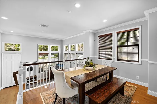 a kitchen with stainless steel appliances granite countertop a table chairs sink refrigerator and microwave