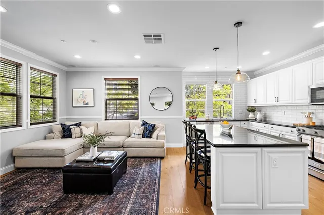 a living room with furniture a fireplace a flat screen tv and a large window