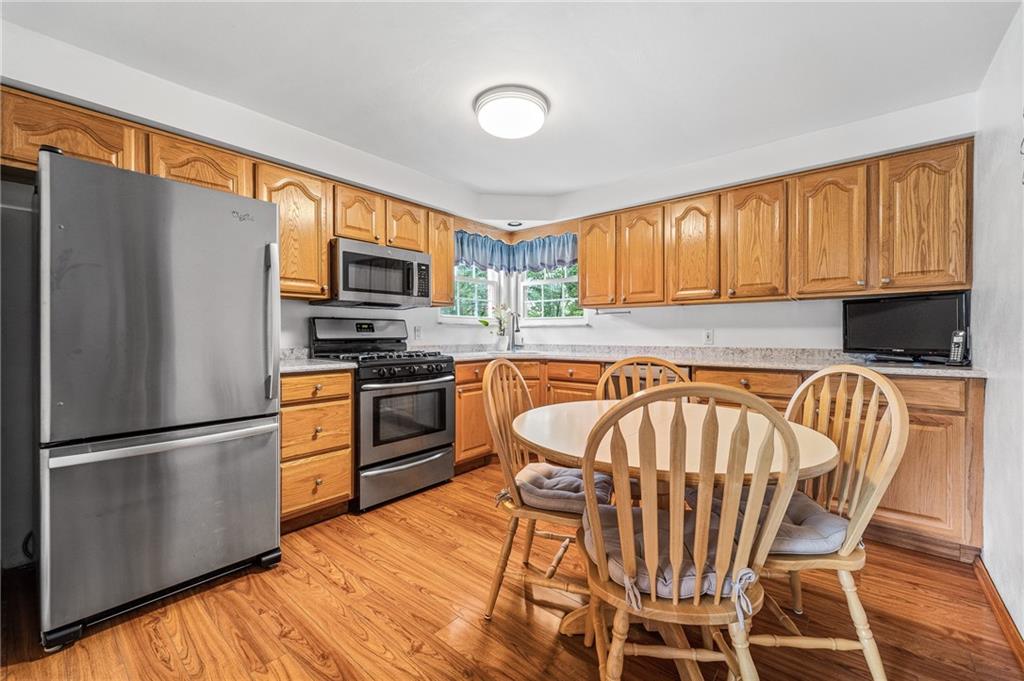 239 Roberts Road Pittsburgh, PA 15239 - Photo 11 of 30 a kitchen with granite countertop a refrigerator stove top oven dining table and chairs