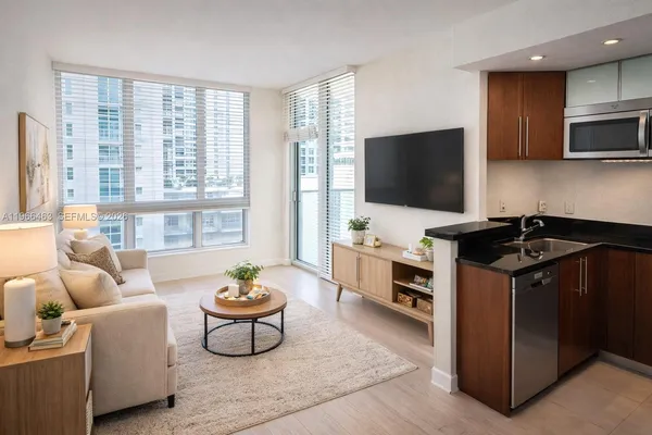 a living room with furniture a flat screen tv and a floor to ceiling window