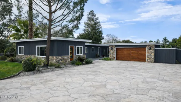 a front view of house with yard and trees around