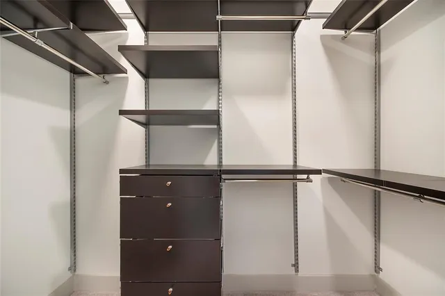 a view of walk in closet with empty racks