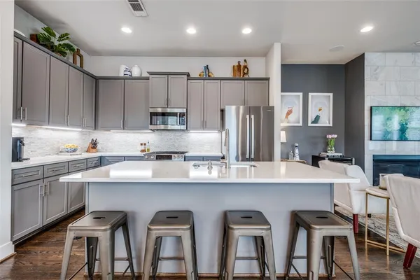 a kitchen with white cabinets and chairs
