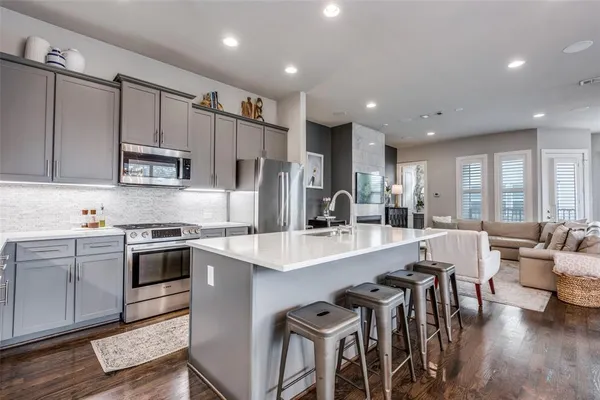 an open kitchen with kitchen island wooden cabinets and stainless steel appliances