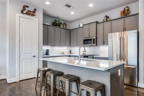 a kitchen with granite countertop a refrigerator and a sink