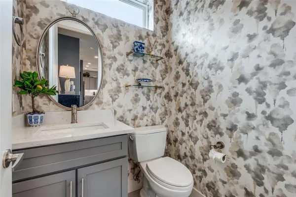 a bathroom with a granite countertop toilet sink and mirror