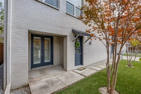 a front view of a house with a garden and tree