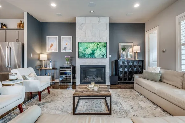 a living room with furniture a fireplace and a large window