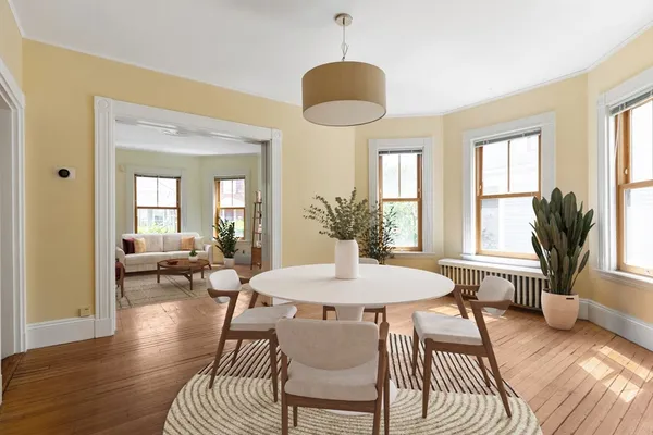 a view of a a dining room with furniture window and wooden floor