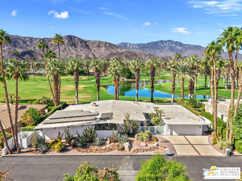 40181 Sand Dune Road Rancho Mirage, CA 92270 - Photo 2 of 75 a view of a patio with a table and chairs under an umbrella with large trees