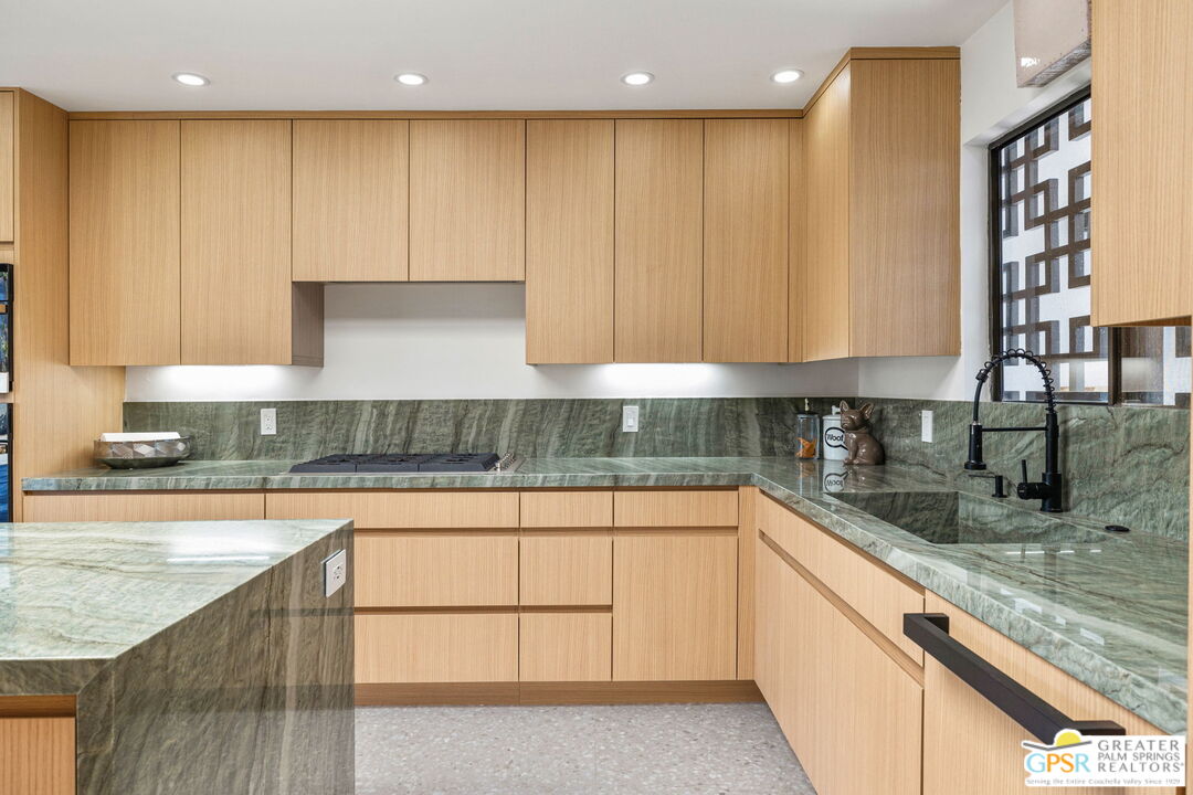 40181 Sand Dune Road Rancho Mirage, CA 92270 - Photo 31 of 75 a kitchen with kitchen island granite countertop a sink a stove and cabinets