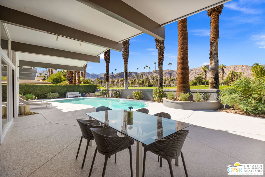 40181 Sand Dune Road Rancho Mirage, CA 92270 - Photo 72 of 75 a view of a patio with a table chairs and a floor to ceiling window