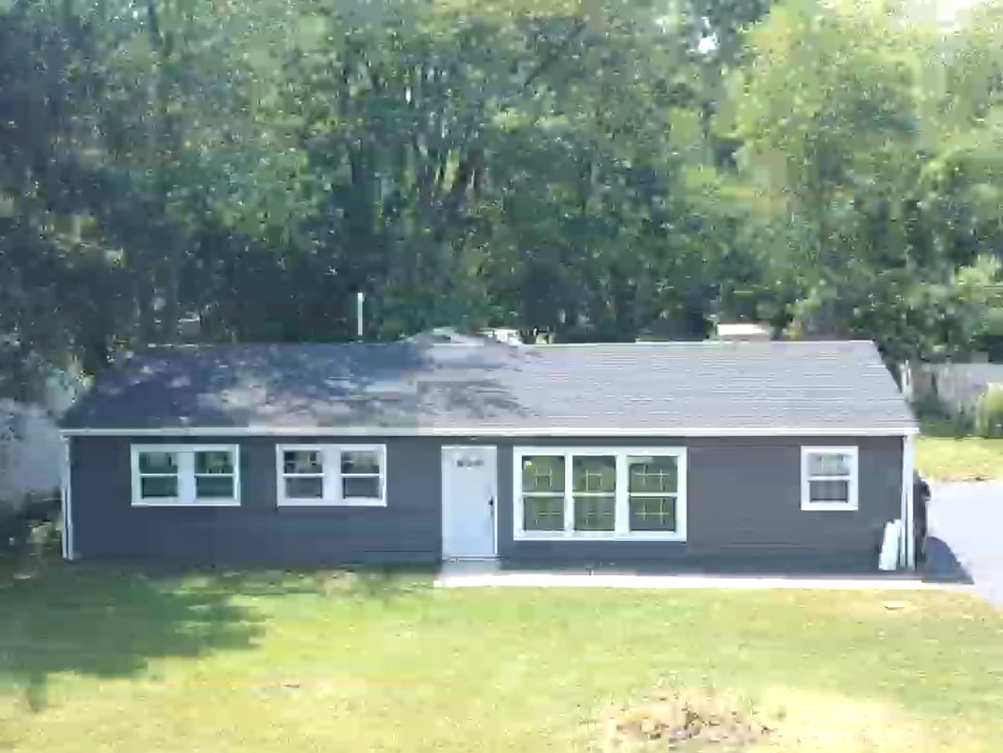 a view of a yard in front of a house with large tree