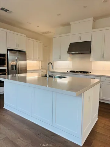 a kitchen with stainless steel appliances granite countertop a sink a stove and a refrigerator