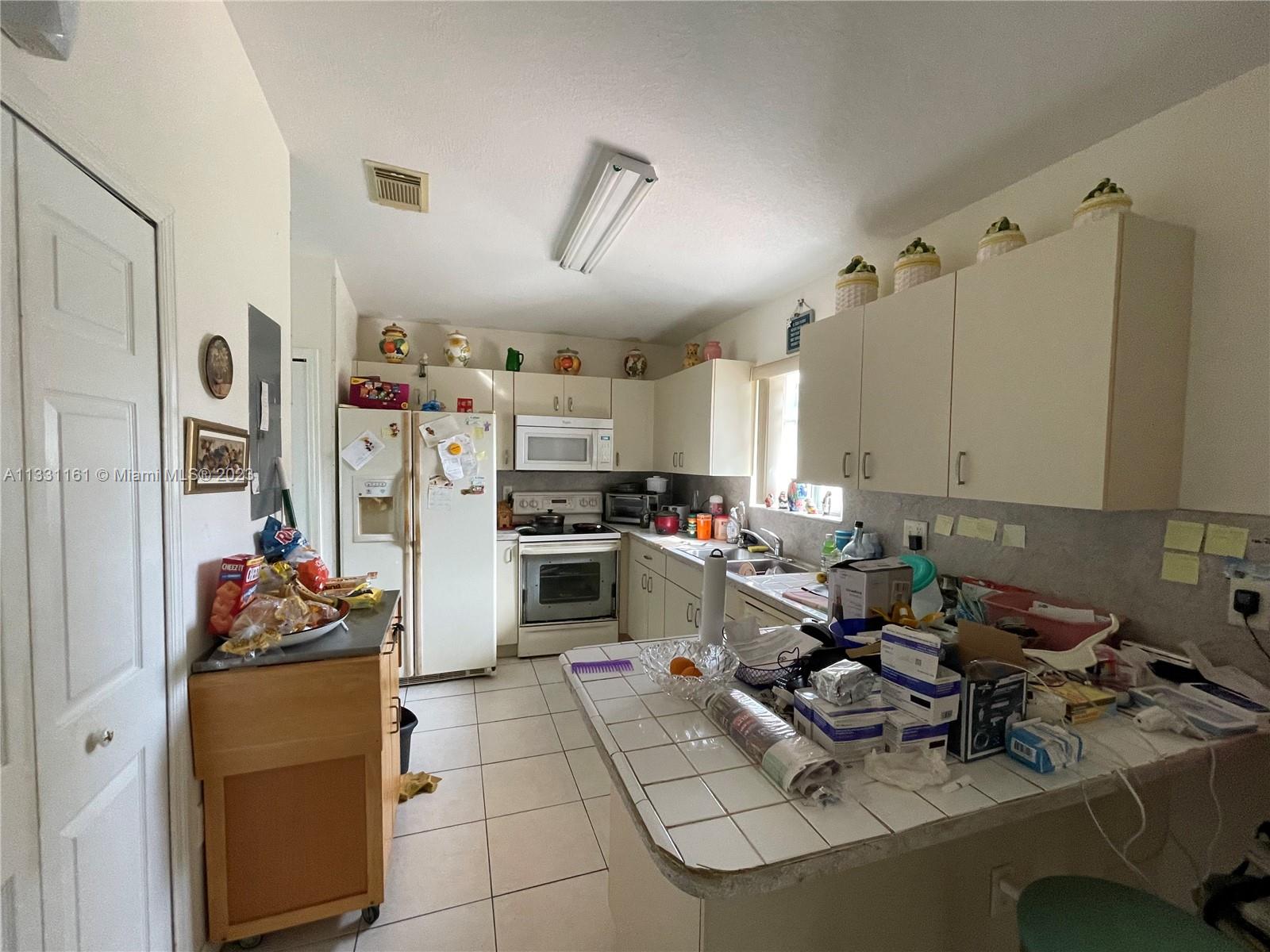12472 Southwest 220th Street Miami, FL 33170 - Photo 3 of 10 a kitchen with refrigerator and stove