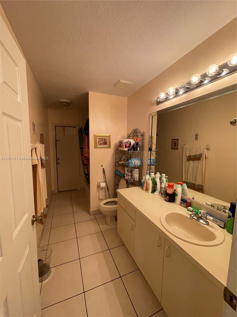 12472 Southwest 220th Street Miami, FL 33170 - Photo 5 of 10 a bathroom with a sink a toilet and mirror