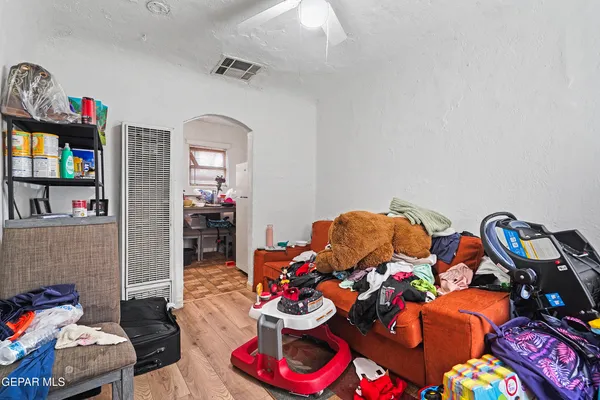 a living room with lots of baby toys and wooden floor