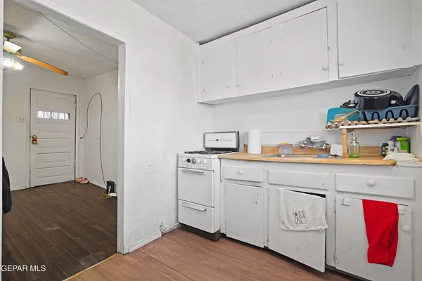 a kitchen with white cabinets and sink