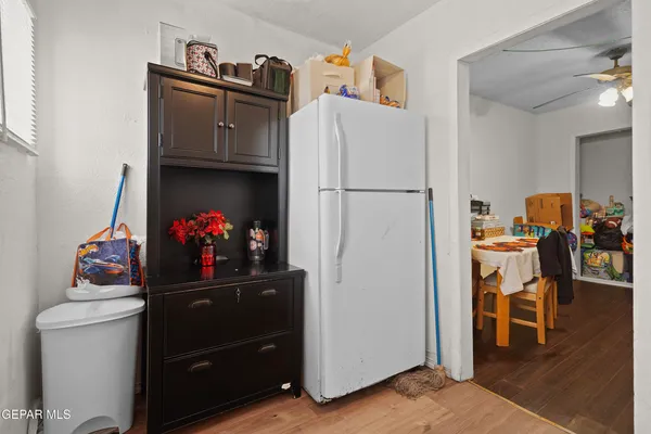 a room with a refrigerator and a wooden floor