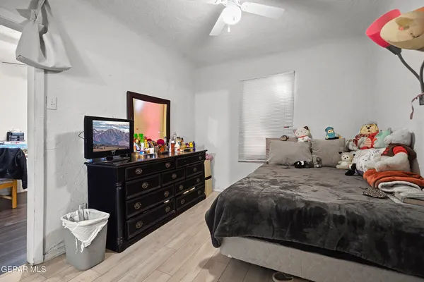 a bedroom with a bed and a mirror on the dresser