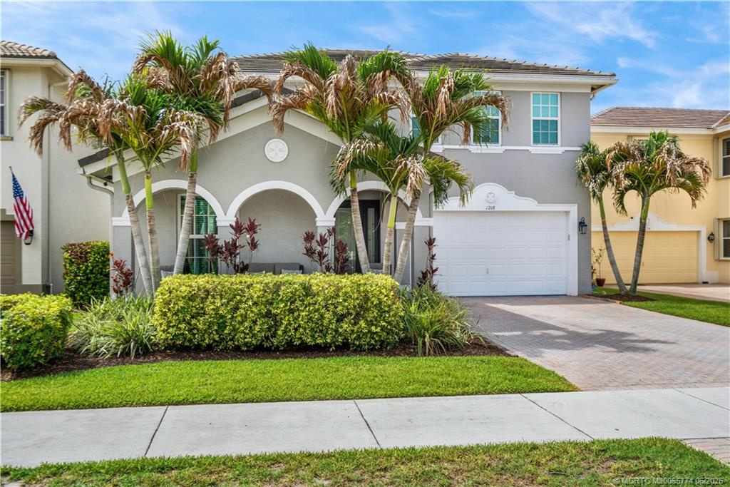 1268 Southeast Kirk Street Stuart, FL 34997 - Photo 7 of 63 a front view of a house with a garden