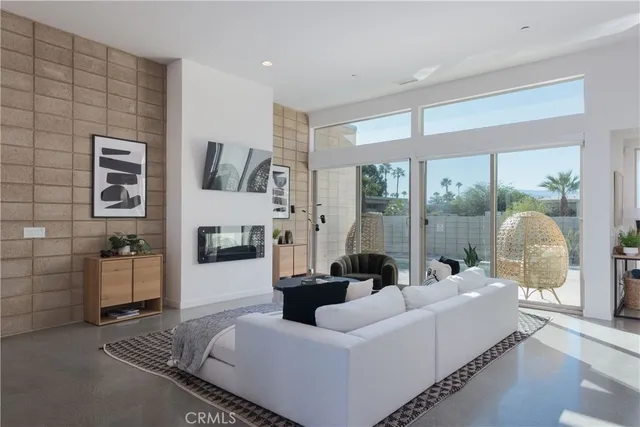 a living room with furniture fireplace and a large window