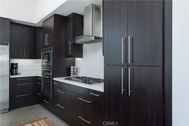 a kitchen with stainless steel appliances granite countertop a refrigerator and a stove top oven