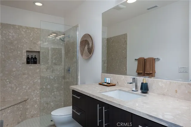 a bathroom with a granite countertop sink a toilet and mirror