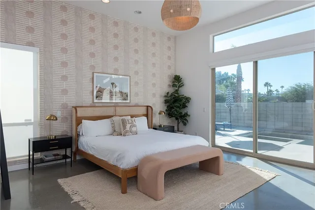 a bedroom with a large bed and a potted plant