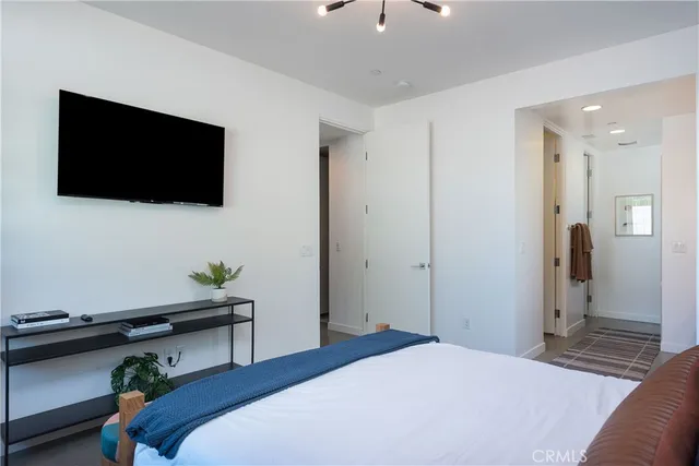 a bedroom with a bed and a flat screen tv